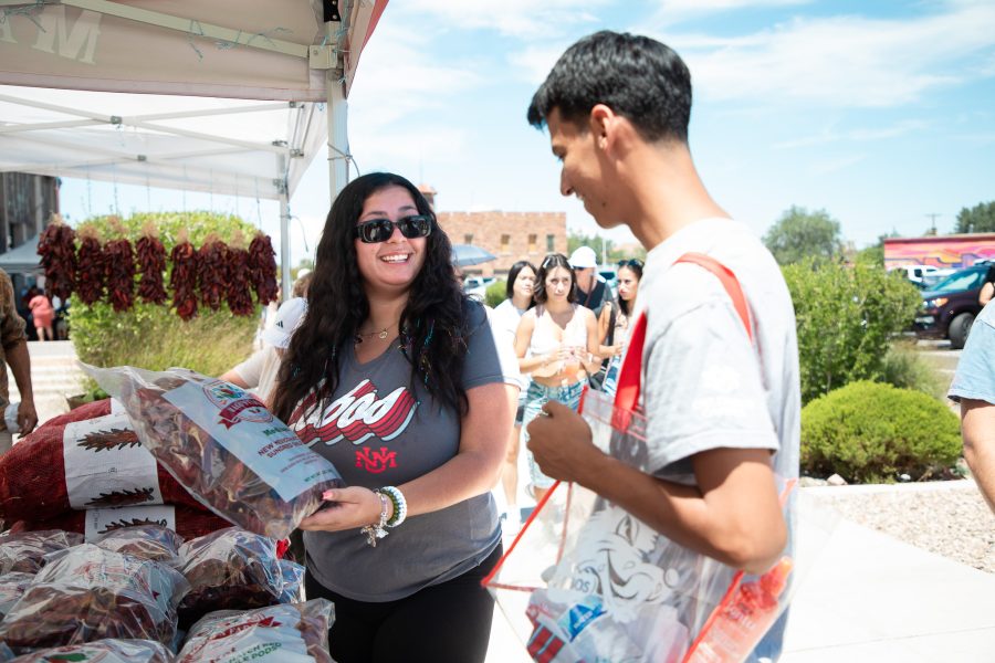 Two UNM students look at some dried red chile at the Rail Yards Market.