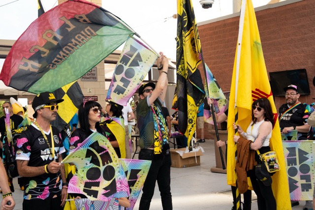 NM United fans wave colorful flags, including the state flag of New Mexico.