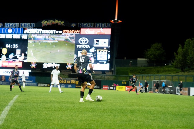 A NM United player prepares to pass the ball.