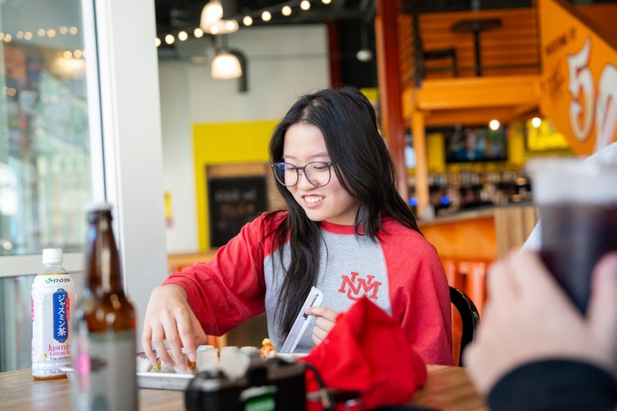 A student smiles as they enjoy their meal.