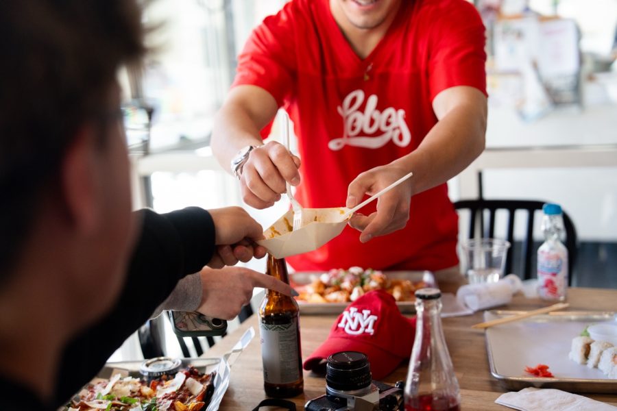 Two students pass their plates to one another to share.