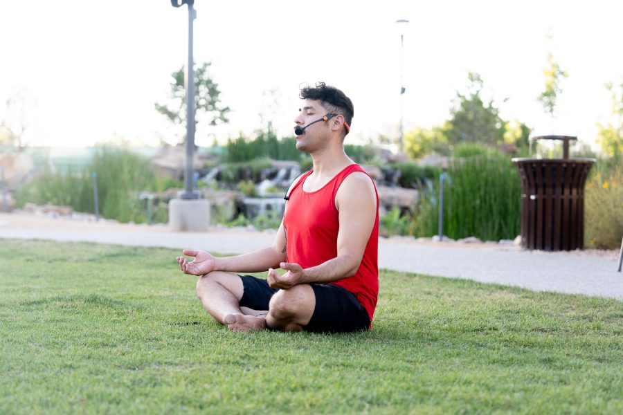 A yoga instructor does the lotus pose in the park.
