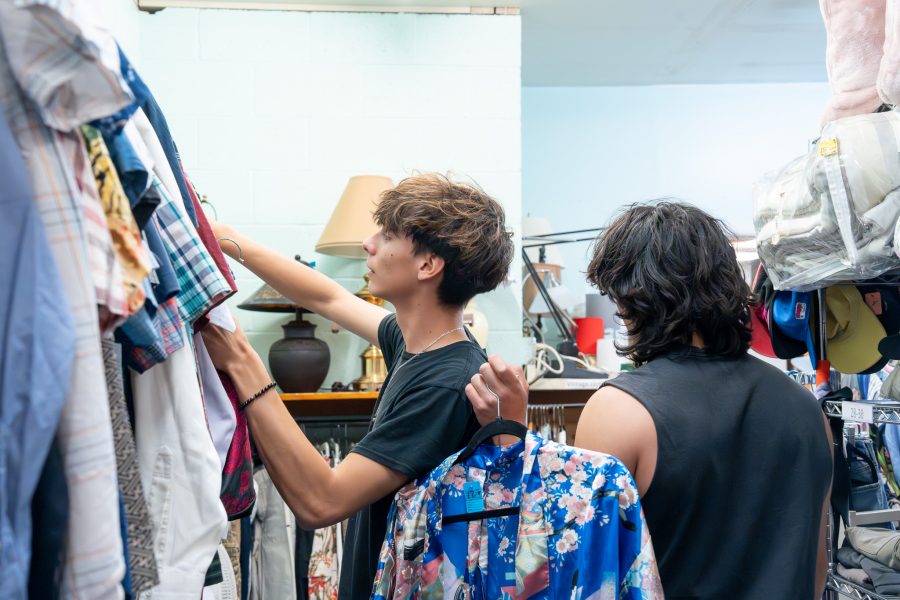 Two students look through clothing and other second-hand items inside Talking Talons Thrift Store.