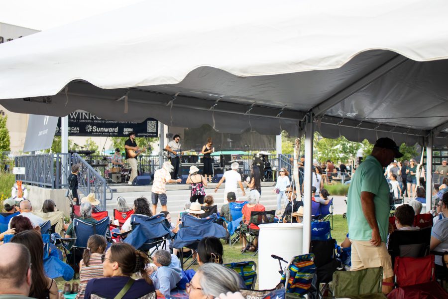 A large crowd in the park watches Los 33 ABQ perform.
